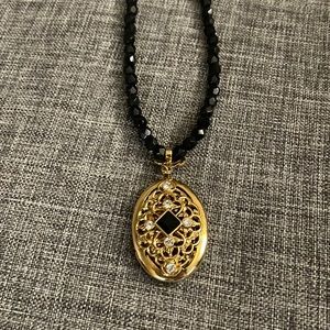 Vintage 1928 black, gold and rhinestone locket on black bead necklace.